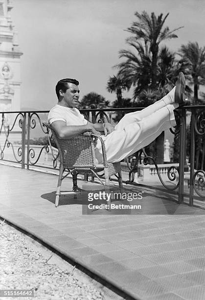 Cary Grant, film idol, is snapped as he recently appeared in the gardens of the Hotel de Paris where he stopped on his vacation tour which will carry...