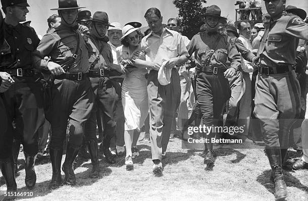 Police escort Byron Nelson and his wife from the 18th green after Nelson had won the U.S. Open Golf Championship.