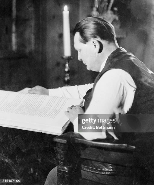 Goering Reads Mein Kampf in His Home. Near Berlin, Germany: Herman Goering, the man whom Hitler has named as his successor, reading a special edition...