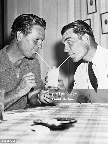 Jimmy Demaret and Ben Hogan share a glass of milk in Augusta, Georgia during the Masters Golf Tournament.