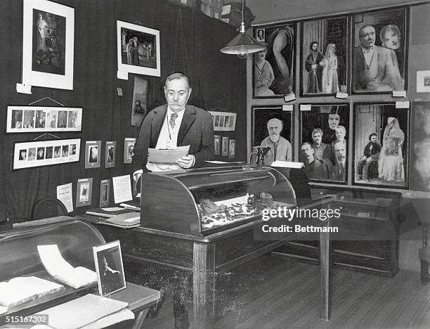 The late Sir Arthur Conan Doyle, one of the world's most famous spiritualists as he appeared in his study surrounded by photographs and miscellaneous...