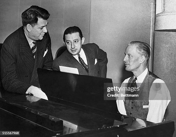 Oscar Hammerstein II, Billy Rose, and Russel Bennett script writer, producer, and conductor respectively are shown as they conferred at a rehearsal...