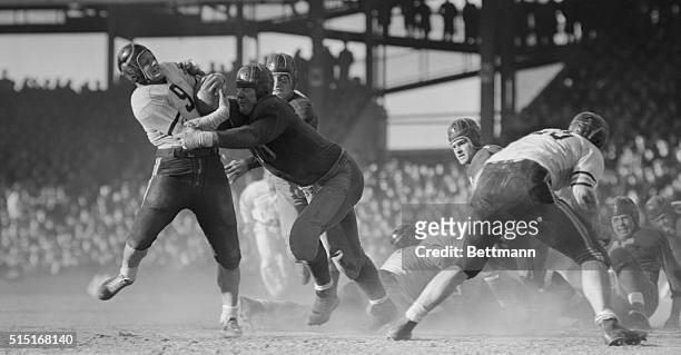 Bill Osmanski, of the Chicago Bears, is brought down by Willie Wilkin after a short gain helping snow under the Washington Redskins, 73-0, for the...