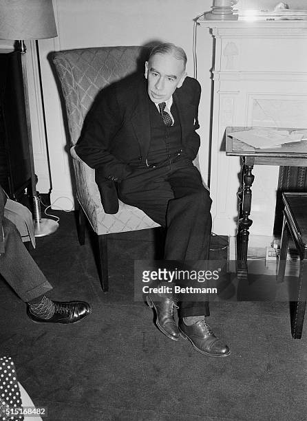 Photo of John Maynard Keynes, the first Baron Keynes of Tilton and the son of John Neville Keynes, shown seated with his hands in his pockets. He is...