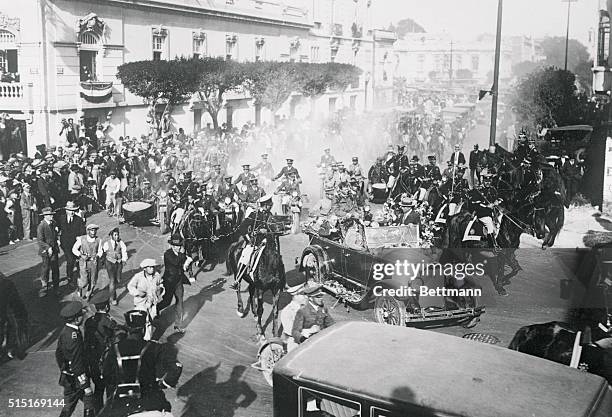 Charles Lindbergh seated atop an automobile riding through the streets of Mexico City as the crowds roared their Vivas to the flyer after completing...