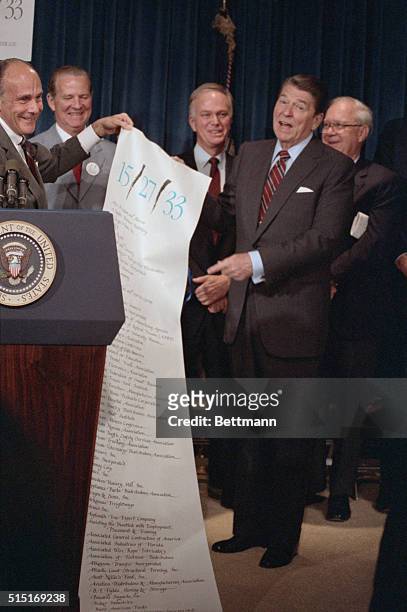 Washington: John Richman, , displays a scroll containing the names of members of the coalition on tax reform, 6/10, following a speech by the...