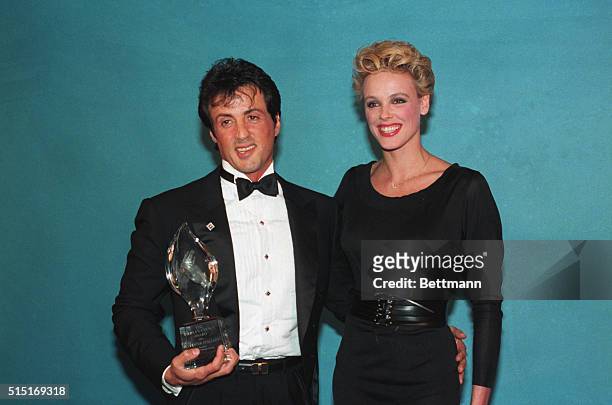 Los Angeles, California: Sylvester Stallone and his wife Brigitte Nielson are all smiles as he displays his People's Choice award.