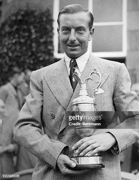 Henry Cotton is shown smiling as he holds the trophy for winning the British Open at Carnoustie Golf Course, Carnoustie, Scotland.