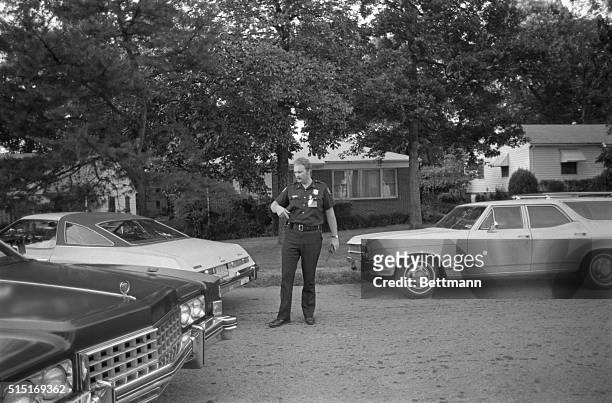 An Atlanta policeman directs traffic in front of the home of Wayne B. Willaims after Williams was arrested and charged with the murder of Nathaniel...