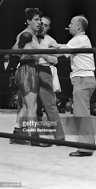 "Now, Now, Rocky, It's All Over." Bronx, New York: Referee Ruby Goldstein and trainer "Whitey" Bimstin hold Rocky Graziano as the maddened fighter...