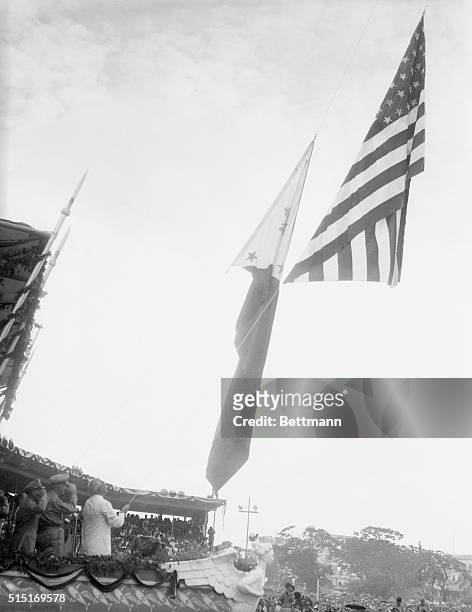Manila, P. I.: New Flag Rises In The Pacific. Filipinos stand bare headed in the pouring rain here July 4th, as the Stars and Stripes are lowered,...