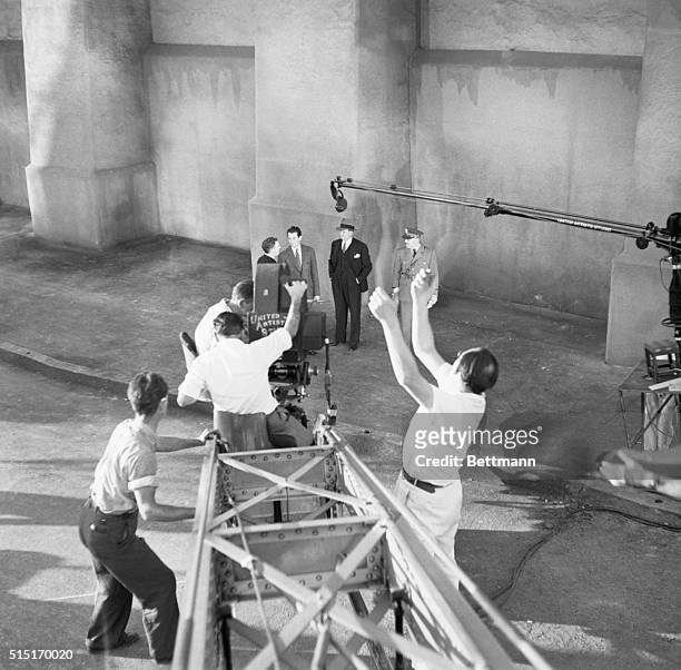 Director Fritz Lang directs actors Henry Fonda, Barton MacLane and William Gargan in a particular camera angle in Walter Wanger's production, "You...