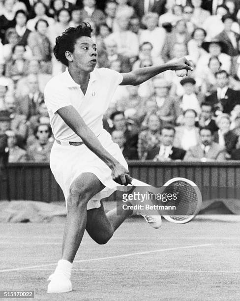 London, England- Althea Gibson, in action at Wimbledon, is shown is some fancy hand and foot action during play against Mrs. Z. Kormoczy of Hungary...