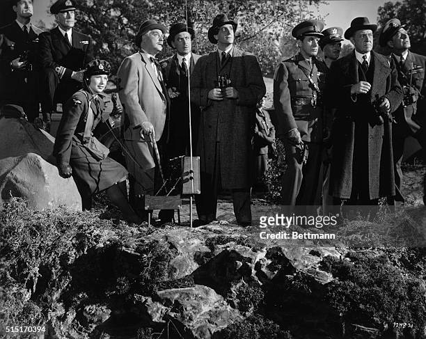 Dr. Watson and Sherlock Holmes observe the tests of the new super-bombsight which they have saved from the Nazis, while members of the British...