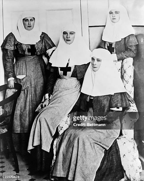 Russian Empress Alexandra sits between her two eldest daughters, Olga and Tatiana, and Anna Vyrubova .