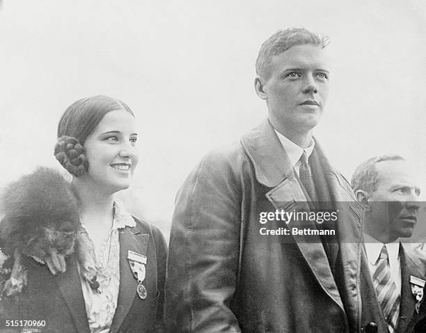 The gentleman to the right can easily be recognized as Colonel Charles A. Lindbergh, first man to fly across the Atlantic from New York to Paris. If...