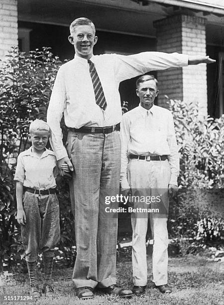 Robert Wadlow, Alton, Illinois, giant, was 7 feet 4 inches tall and weighed 290 pounds at the age of 13. He is shown here with his father, Harold...