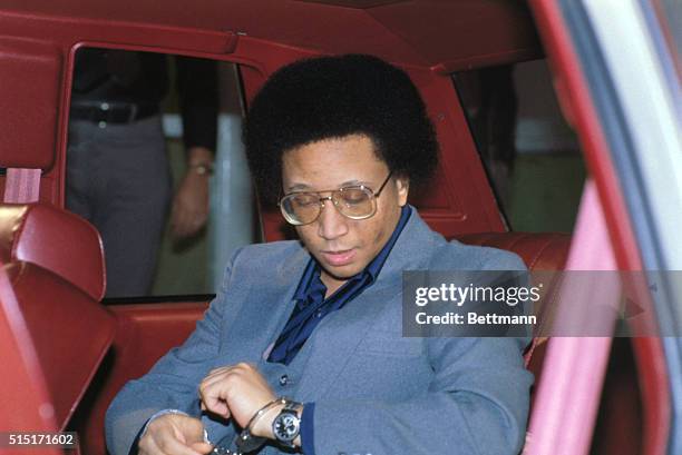 Accused in Atlanta child murders, Wayne Williams is in handcuffs as he leaves car for his court trial in 1982.