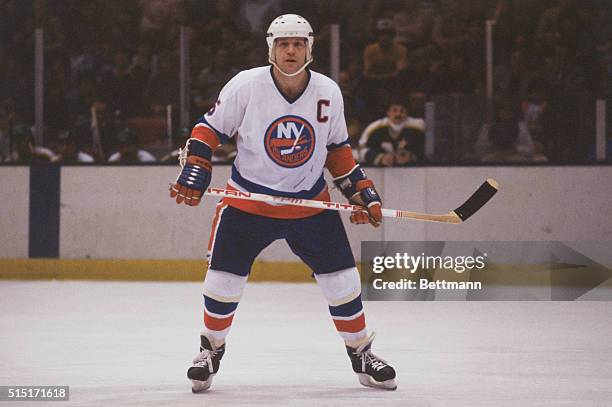 New York Islanders defenseman, Denis Potvin, holding hockey stick during game in 1982.