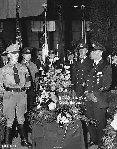 Flanked by an honor guard of uniformed Nazi party members and personnel from the Hamburg-America line , the casket bearing the remains of Captain...
