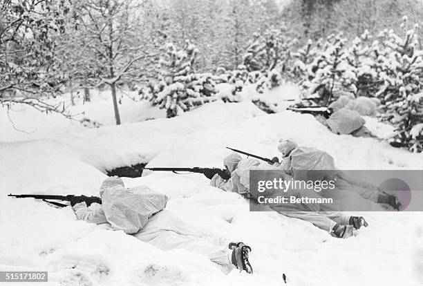 Members of a Finnish patrol are shown firing over the snow when they encountered a Russian detachment on the Petsamo Front.