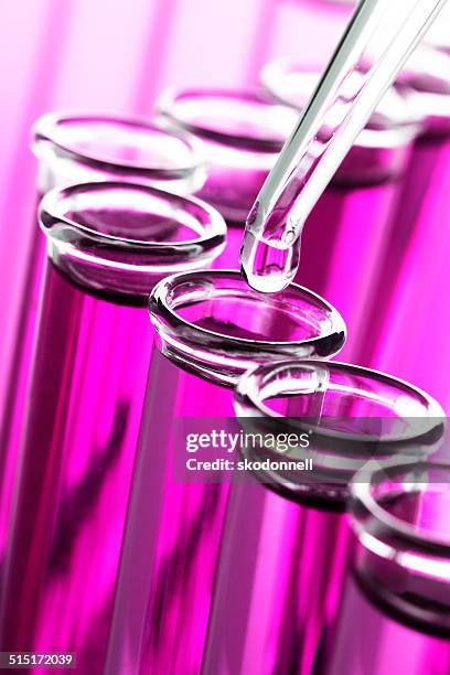 drop of liquid in a test tube - pink tube stock pictures, royalty-free photos & images