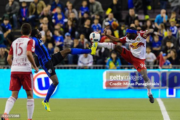 Ambroise Oyongo of the Montreal Impact and Shaun Wright-Phillips of the New York Red Bulls kick the ball during the MLS game at the Olympic Stadium...