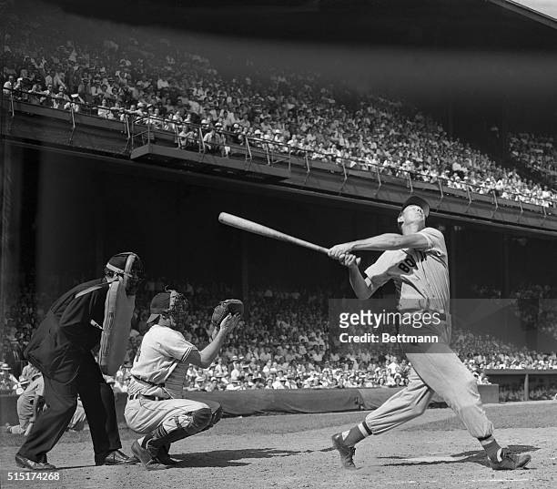 Red Sox slugger Ted Williams takes a terrific out at the ball and misses for a strikeout, the first time that Bobby Feller has been able to get a...