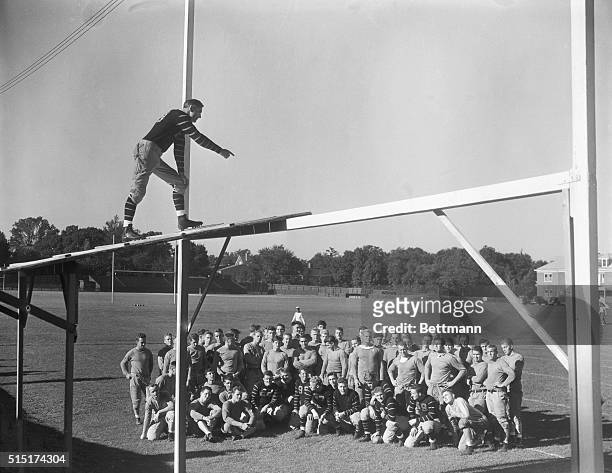 Head Coach Herbert O. Crisler picks an unusual perch as he gives the Princeton football squad a pep talk at training session, here.