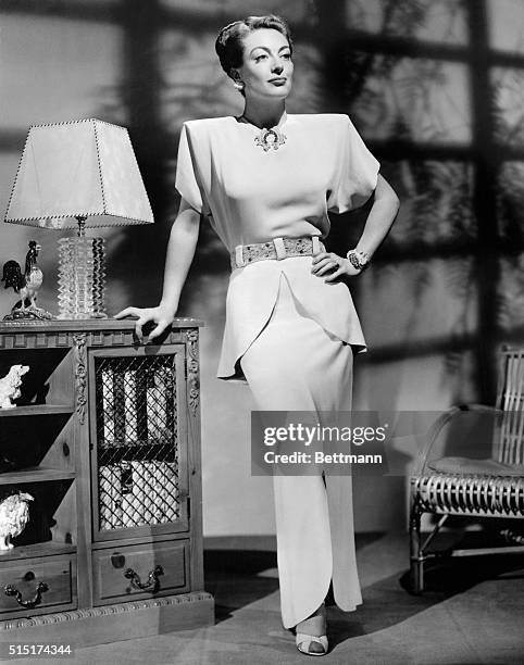 Award-winning actress Joan Crawford models a two-piece silk dinner dress, titled "Change," which was designed by fashion designer Adrian. Crawford...