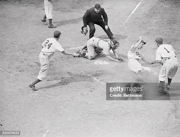New York: Slide For A Score. Dixie Walker, Dodger right fielder, slides past home after scoring in the first inning of the game with Cincinnati at...