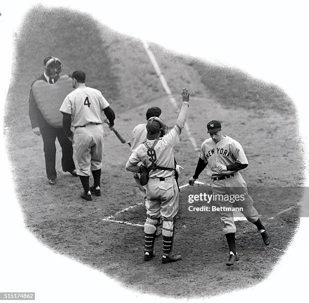 Joe DiMaggio, hard-hitting outfielder of the New York Yankees, is pictured as he crosses home plate after crashing out a homer in the third inning of...