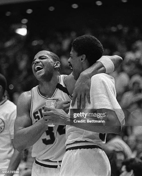 Jubilant Sixers' star Charles Barkley throws his arm around the shoulders of Sixers' Erving as they both enjoy a hearty laugh as the clock wound down...