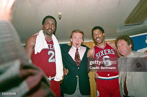 Philadelphia 76ers' Moses Malone and Julius Erving hug their coach Bill Cunninham in the dressing room after the 76ers made a clear 4 game sweep over...