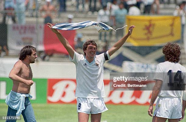 Neza, Mexico: Uruguay's Jorge Barrios waves his nation's flag over his head as he celebrates their 0-0 tie with Scotland that advanced them to the...