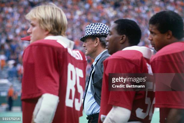Paul "Bear" Bryant, University of Alabama football coach, watches the team practice from a tower on the side of the field.
