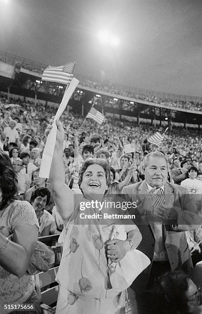 Miami: Alejandrina Hernandez and her husband Pascual, West Palm Beach, wave American flags in a crowd of 14,000 immigrants at the Orange Bowl 7/3....