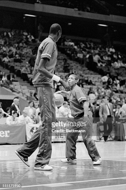 East Rutherford, New Jersey: Washington Bullets' Tyrone Bogues, who is one of the smallest men in the NBA, at 5-4 looks up to Bullets' Manute Bol who...