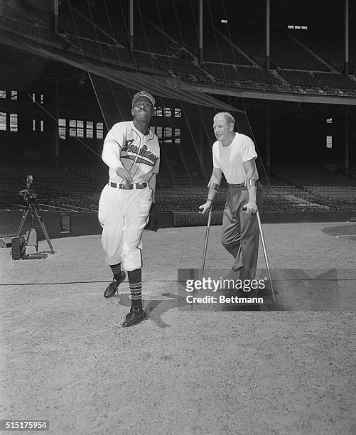 Cleveland, Ohio: Showing Veech How Its Done. "satchel" Paige demonstrated his pitching arm to Bill Veeck, Cleveland Indians president, during a...