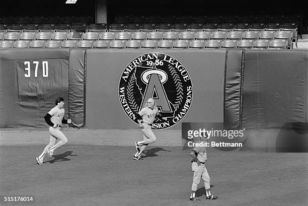 Boston Red Sox pitcher, Al Nipper, wearing a Halloween mask, runs through the outfield during pre-game warm-ups here. Following him is Red Sox...
