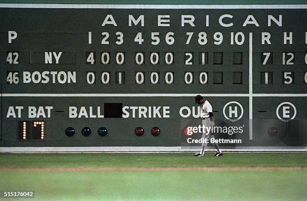 Red Sox left fielder Jim Rice is framed against the scoreboard as time is running out with the Mets holding a commanding 7-1 lead in the 9th inning...
