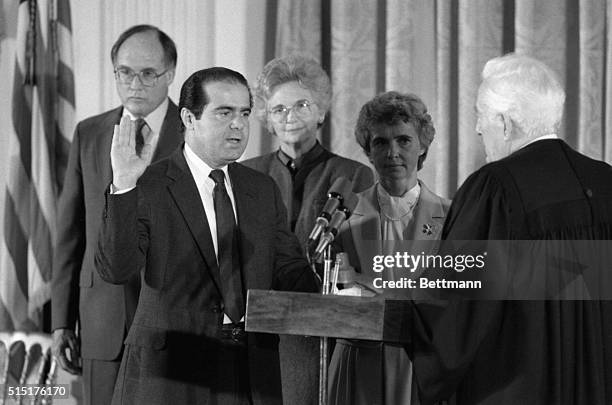 Antonin Scalia is sworn in as associate justice of the Supreme Court by Chief Justice Warren Burger, , at the White House, 9/26. Looking on are ,...