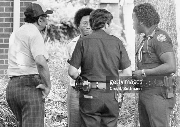 Wayne Williams and his father talk to policemen on the lawn of their home. A witness who reported seeing 23-year-old Wayne Williams with on eof...