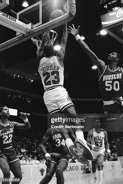 Long stretch by the Rockets' Ralph Sampson is not enough to stop Bulls' Michael Jordan from getting a slam dunk in the first quarter of the game in...