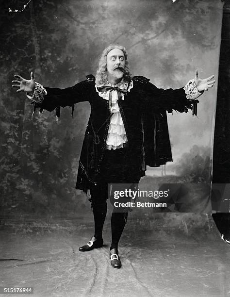 Early actor in Shakespearean costume emoting, making gesture with arms extended. Undated photograph.