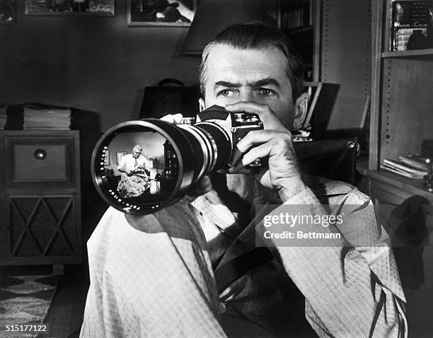 James Stewart watches Raymond Burr through a camera lens in Alfred Hitchcock's "Rear Window" . Photograph. BPA2# 3712