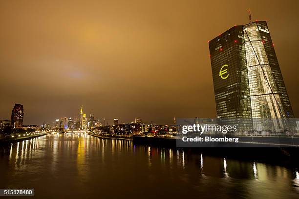 An illuminated euro currency symbol is projected on to the European Central Bank headquarters during a rehearsal for the Luminale light festival in...