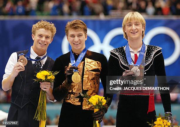 Timothy Goebel of the US, Russian Alexei Yagudin and his compatriot and concurent Evgeni Plushenko jubilate on the podium at the end of the men's...