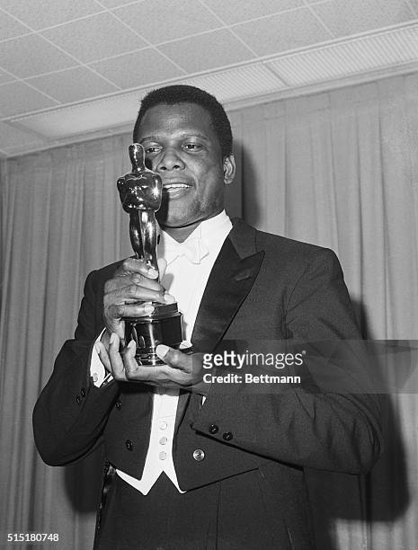 Sidney Poitier admires the Oscar he has just received in Santa Monica, California, on April 13, 1964. He won Best Performance by an Actor for his...