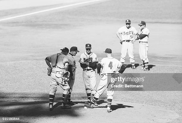 Conference on mound during first game of the 1957 World Series. Left right are: Del Crandall; Fred Haney; and Warren Spain.